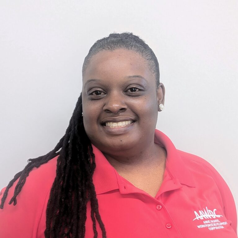 Person smiling in a red AAWDC polo shirt against a plain light background.