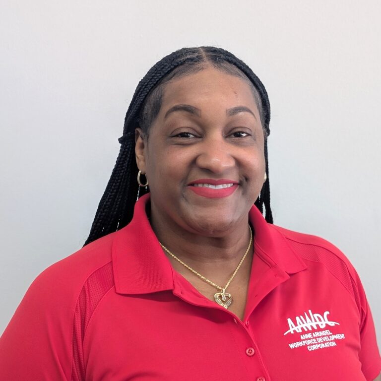 Woman smiling and wearing a red polo shirt with the AAWDC logo.